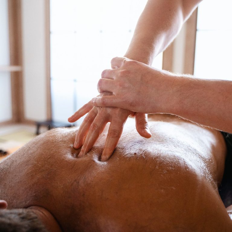 Eine Massage wird auf dem Rücken einer Person durchgeführt.